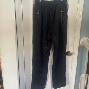Black Wilson polyester sweat pants with front zippers and leg zippers